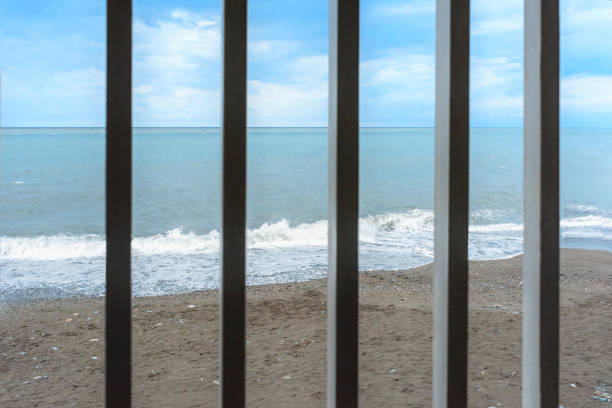 View of the sea coast through the railing. Beach on the sea coast.