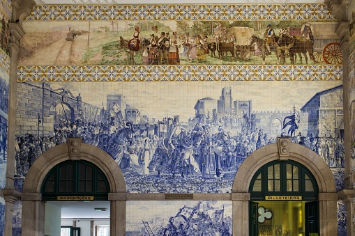 Porto, Portugal – August 17, 2015: Vintage Azulejos tiles inside main hall of Sao Bento Railway Station, installed between 1905 and 1906 by artist Jorge Colaco.