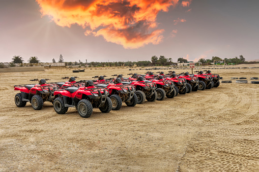 large group of quad 4x4 quad bikes parked in the sand on the track, touristic attraction