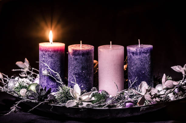 una candela accesa sulla corona dell'avvento - advent wreath foto e immagini stock