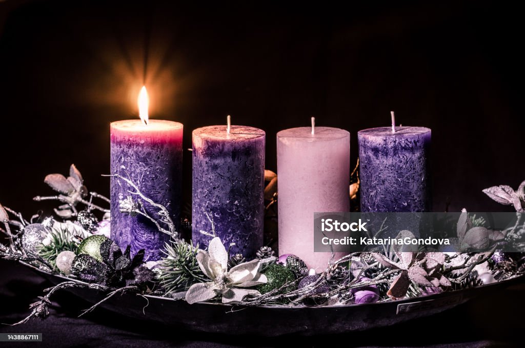 one burning candle on advent wreath advent cristian concept with 1 pink candle and 3 purple candles Candle Stock Photo