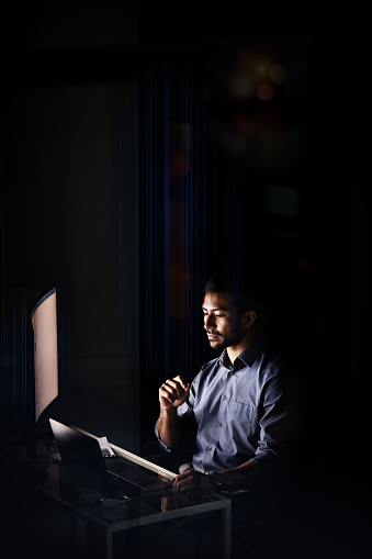 Asian man, computer or businessman working at night in office trading, marketing or networking for corporate strategy. Manager, employee or digital hacker for research, website security or analytics