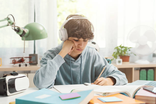 istock Student listening to music and doing homework 1438867915