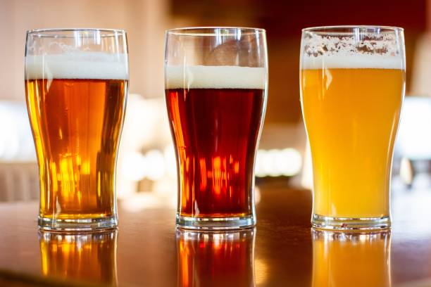 istock Cups of beer on a wooden table with a blurred background 1438868763