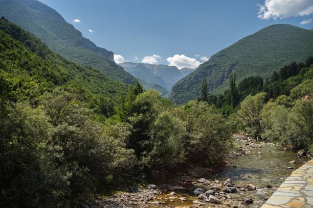 istock River surrounded by hills covered in greenery under a cloudy sky and sunlight 1438871739