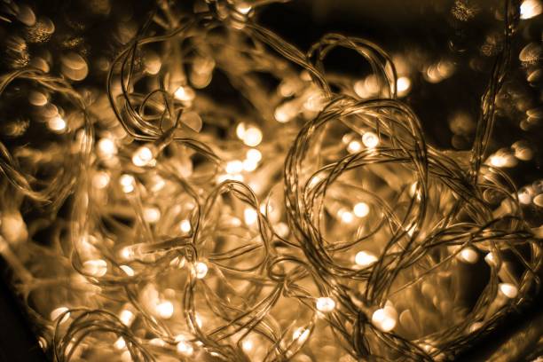 istock Closeup shot of illuminated string lights on a black background 1438872738