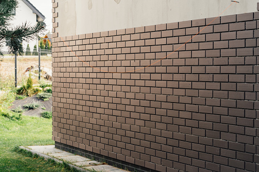 laying clinker tile on the facade of the house