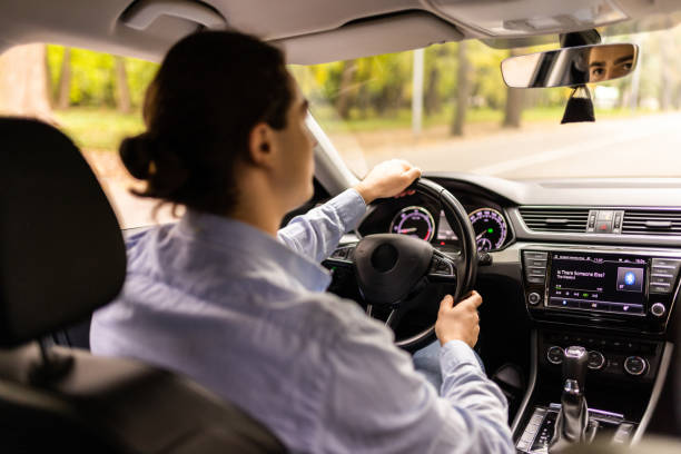 istock Businessman in car. Rear view of young handsome man while driving a car 1438874792