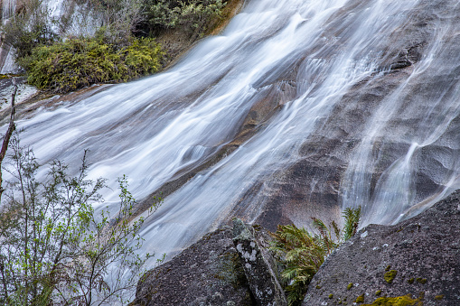 Full frame of gushing water streaming down cool rock face in the blue mountains, Australia