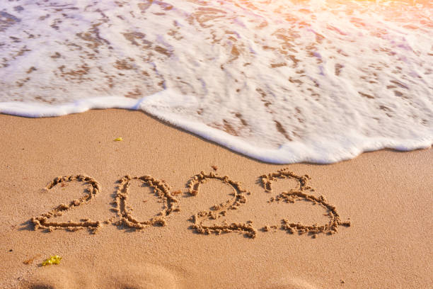 istock 2023 year written on sandy beach sea at sunny day 1438875684