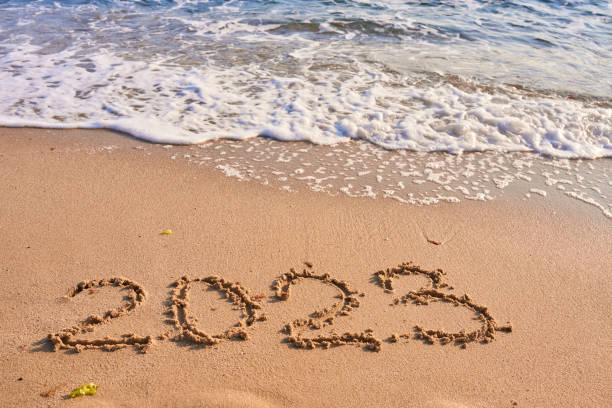 istock 2023 year written on sandy beach sea at sunny day 1438875696