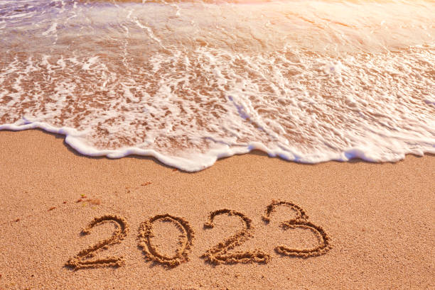 2023 year written on sandy beach sea at sunny day