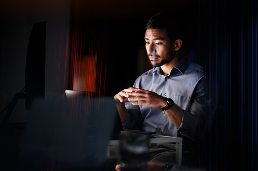Information technology, night and businessman on laptop in dark room with software development, website design or innovation idea mock up. Thinking businessman for trading or cybersecurity strategy