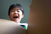 istock Surprised young Asian boy looking into a Box 1438877344