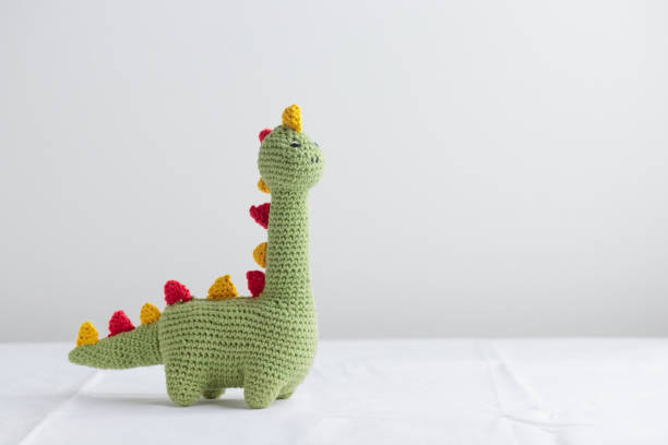 istock Crocheted Cute Green Dinosaur on a white background 1438880212