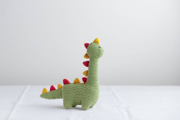 istock Crocheted Cute Green Dinosaur on a white background 1438880217