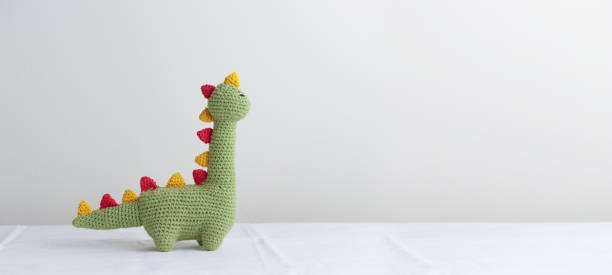 istock Crocheted Cute Green Dinosaur on a white background 1438880269