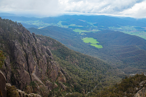 Wide landscape view of a mountains and valleys with stormy backdrop, Australian hinterlands.
