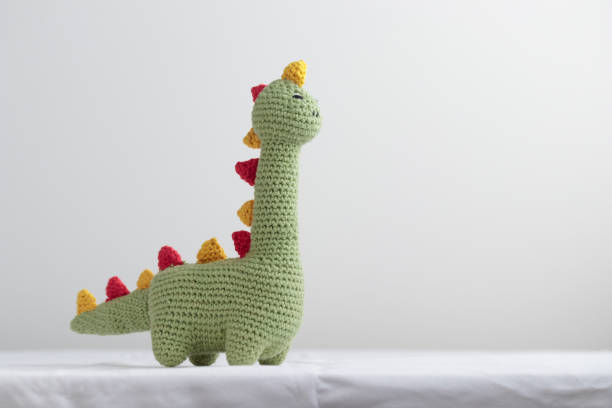 istock Crocheted Cute Green Dinosaur on a white background 1438880402