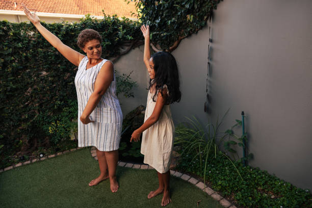 istock Girl and her granny practicing dance moves together at backyard 1438880642