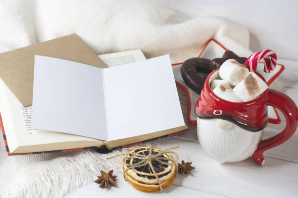 New Year's Eve background, Santa Claus mug with marshmallows, Christmas cookies, open book