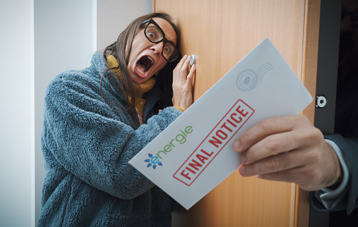Terrified shocked woman receiving expensive utility bills at home, household expenses and debt concept