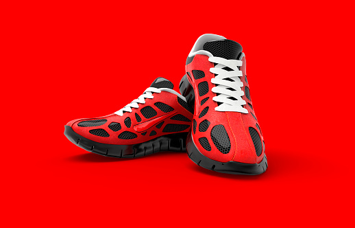 A studio shot of a pair of red running shoes isolated on red background.