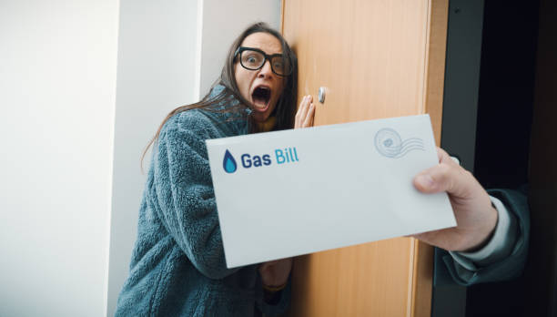 Terrified woman receiving expensive utility bills stock photo