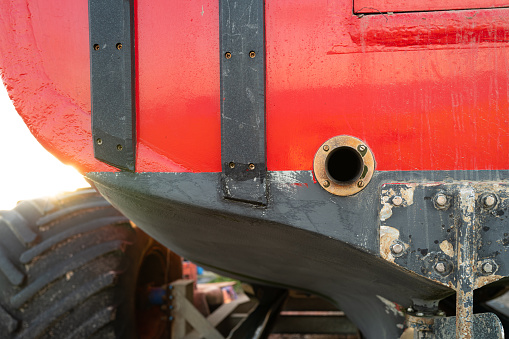 Shallow focus of a brass exhaust hole seen on the rear of a dry docked fishing trawler. Seen on a beach during low tide.