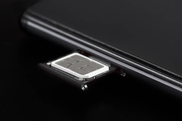 istock SIM card inserted into the sim card tray of a smartphone on dark background 1438884500