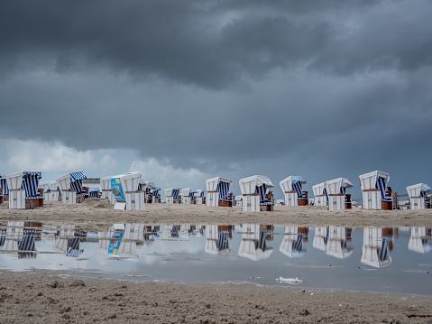 Beach chairs with dark sky on the beach of St.Peter-ording
