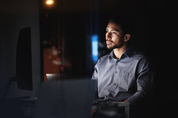 istock Computer, night and overtime with a business man at work in a dark office on global or international deadlines. Internet, manager or desk with a male employee working on a desktop in the late evening 1438887406
