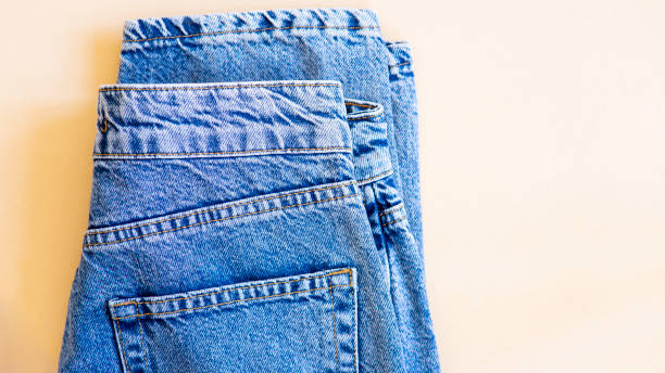 istock jeans on the background, blue and black jeans lie on a white background, 1438889103