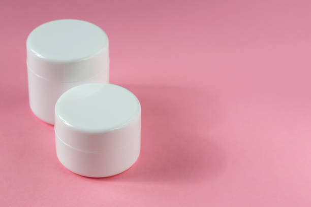 istock Two white cosmetic jars on a pink background 1438891164