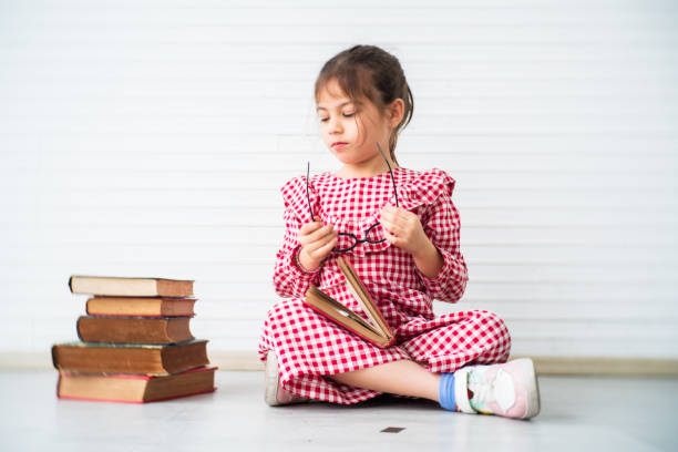 Little girl playing and reading in the room