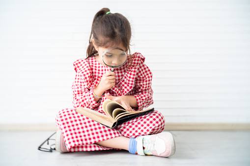 Little girl playing and reading in the room