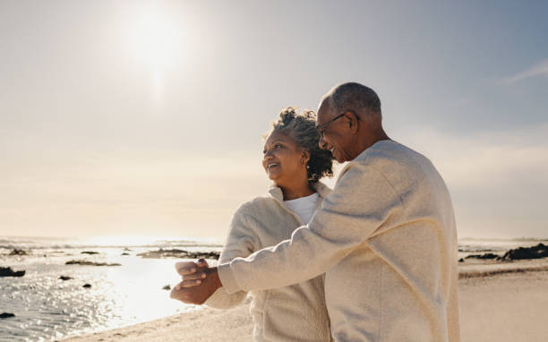 istock Happy senior couple dancing at the beach 1438894851