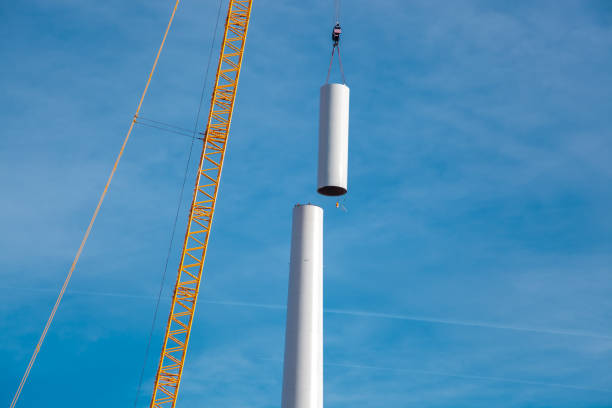 Building and assembling a construction windturbine by crane. Farmland with construction work at the windfarm, Wörrstadt, Germany. Energy crisis concept, wind turbine construction