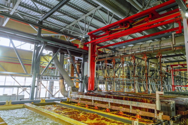 processo de produção de produtos metálicos de aço de cobre galvânico, níquel e cromado. levantamento de produtos metálicos por guindaste aéreo do banho de revestimento eletroquímico. fragmento de uma linha galvânica. - galvanic - fotografias e filmes do acervo