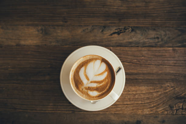 istock White cup with fresh cappuccino on wooden background 1438898391