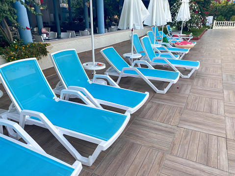 Blue beautiful plastic sunbeds for sunbathing for relaxing in a hotel in a warm tropical oriental country southern resort