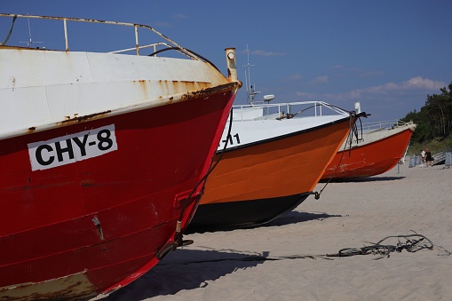 – June 21, 2021: A closeup of red and orange fishing boats on the beach in Chlopy, Poland