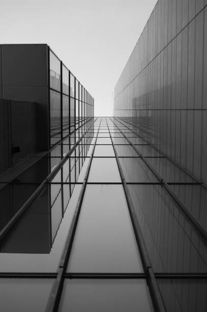escala de cinza de um telhado de um edifício moderno com janelas de vidro sob a luz solar - photography urban scene vertical toned image - fotografias e filmes do acervo