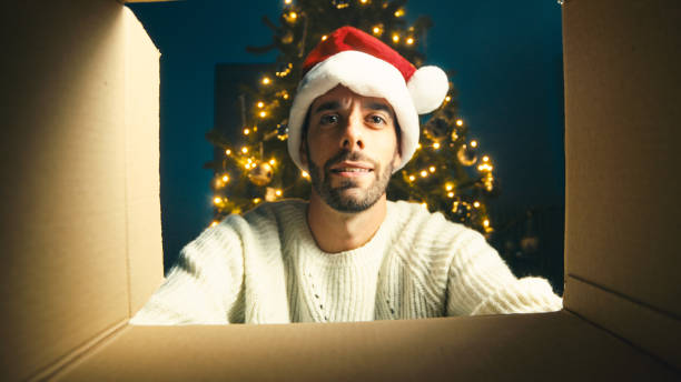 istock Happy guy looks inside a Christmas box 1438904779