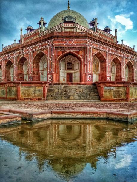 tomb of the mughal emperor humayun reflecting on the rain under a cloudy sky in delhi in india - iraanse cultuur stockfoto's en -beelden