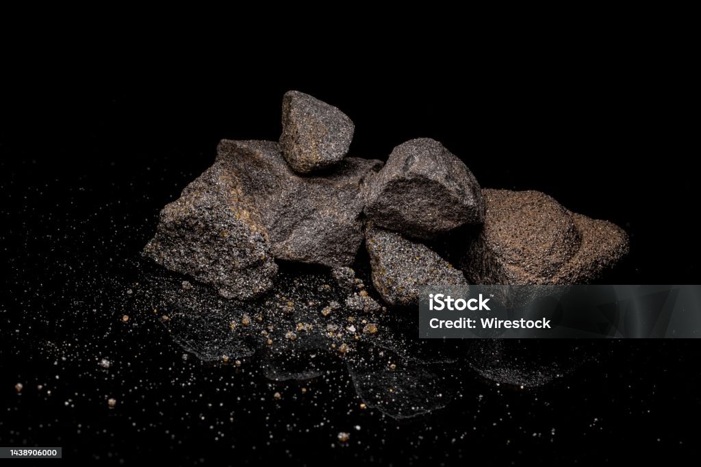Macro Close up image of raw material Platinum and Chrome Ore roc Macro Close up image of raw material Platinum and Chrome Ore rock isolated on black reflective background Alloy Stock Photo