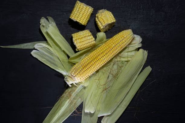 istock Top view of corn in its leaves on a dark surface 1438906500