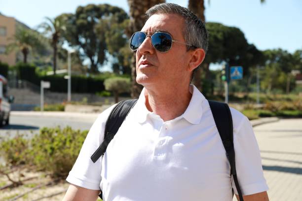 istock Man in a white polo and a backpack walking in Alicante 1438906760