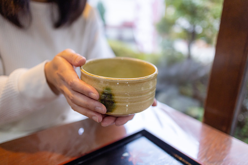 Woman holding a cup of Matcha tea