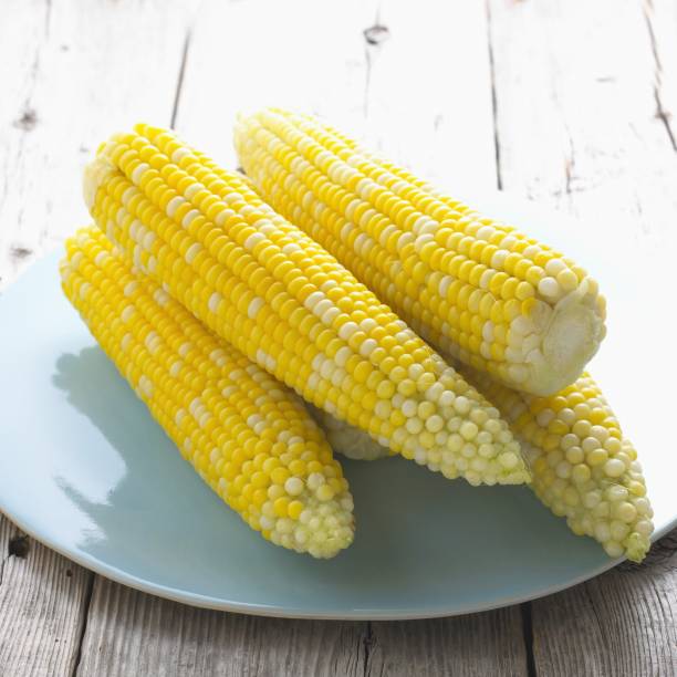istock Boiled corns on the cob on a blue plate 1438908147